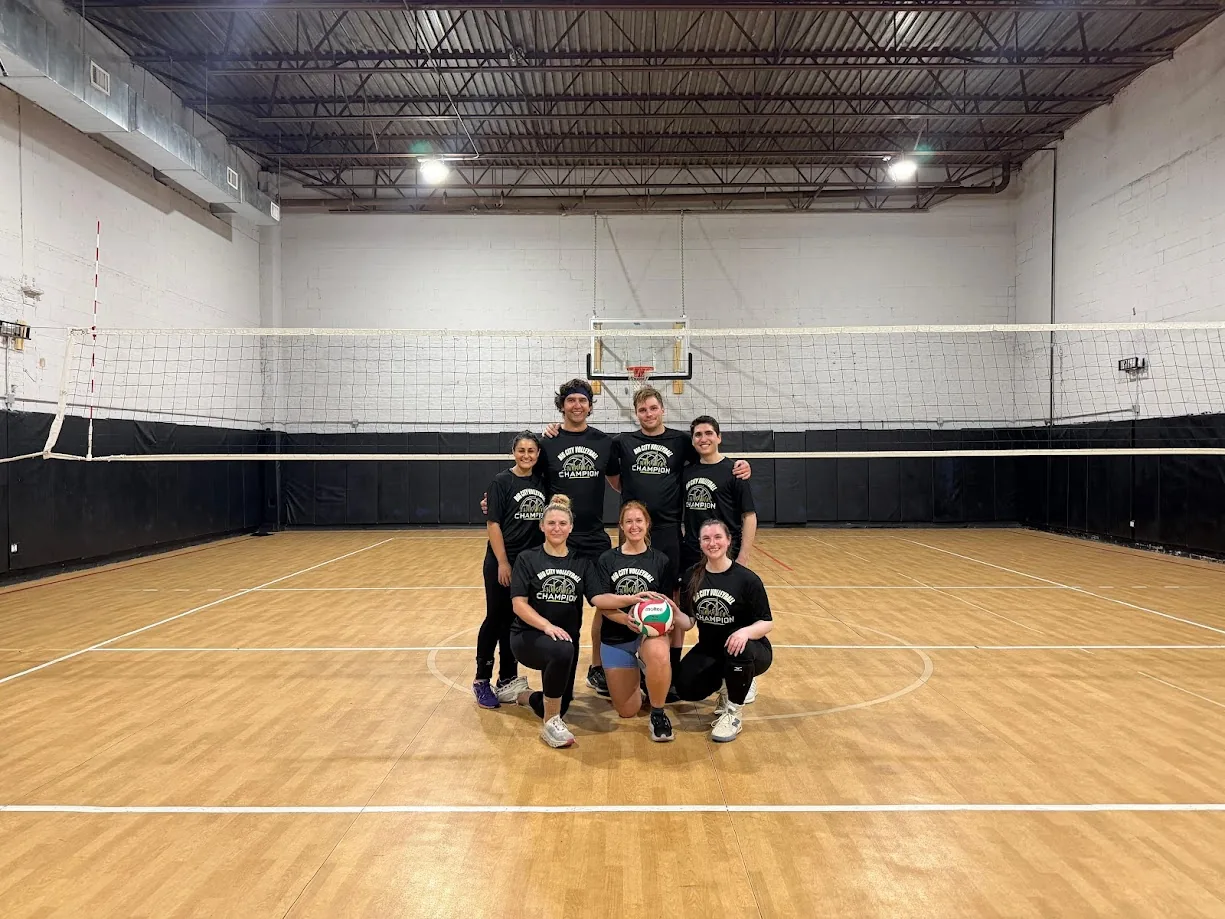 A championship volleyball team posing on an indoor court
